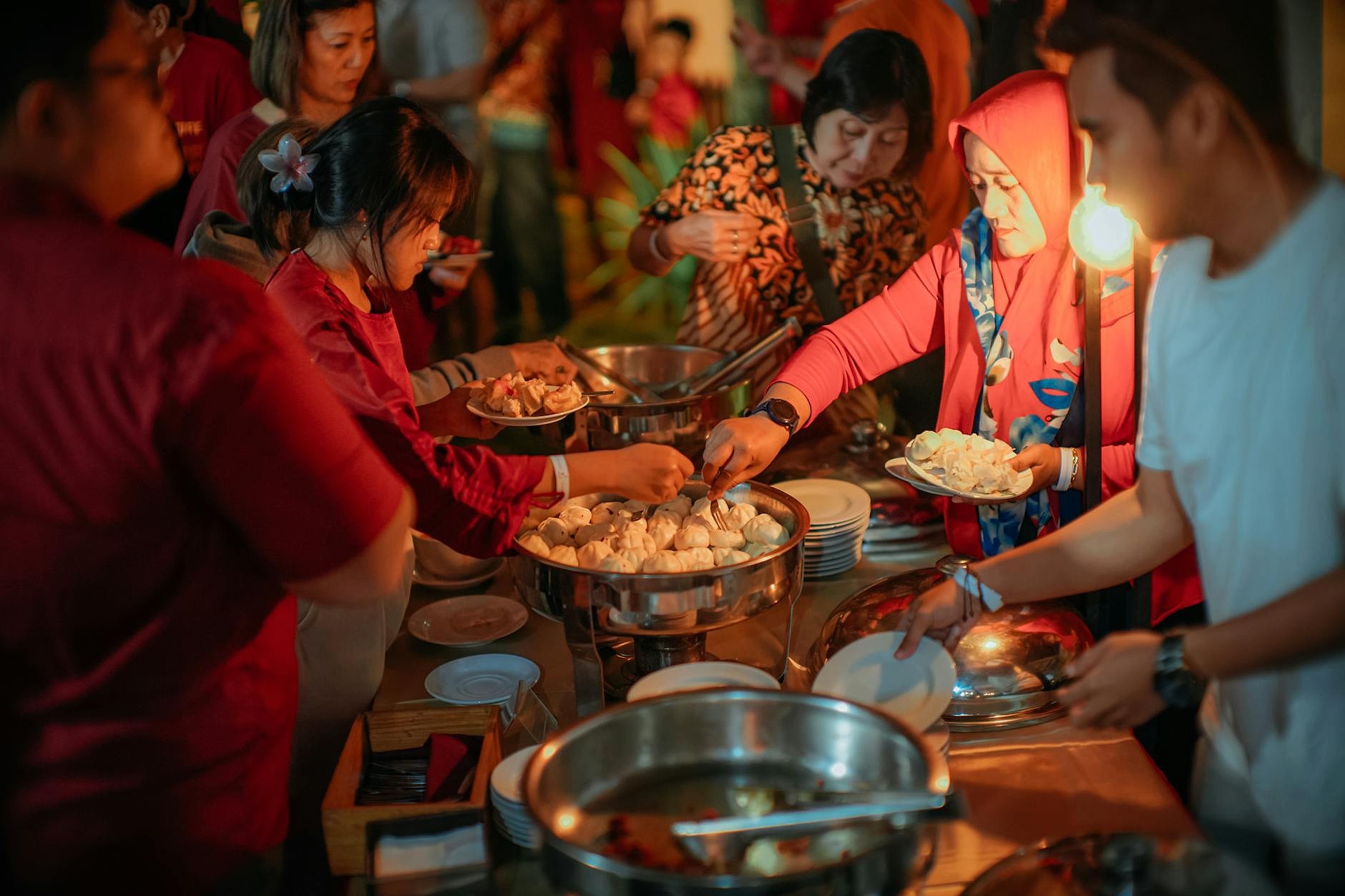 Shared meal event in a community kitchen with neighbours enjoying food together